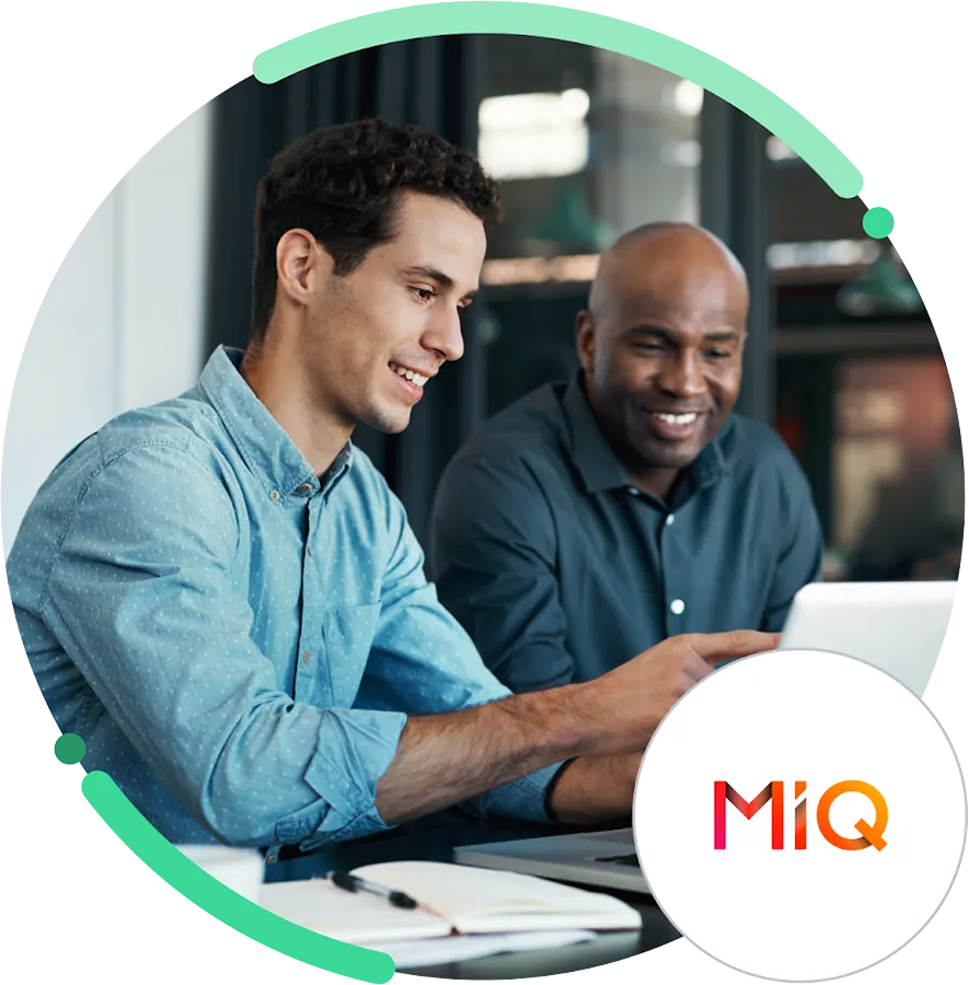 Dos empleados de MIQ mirando una laptop